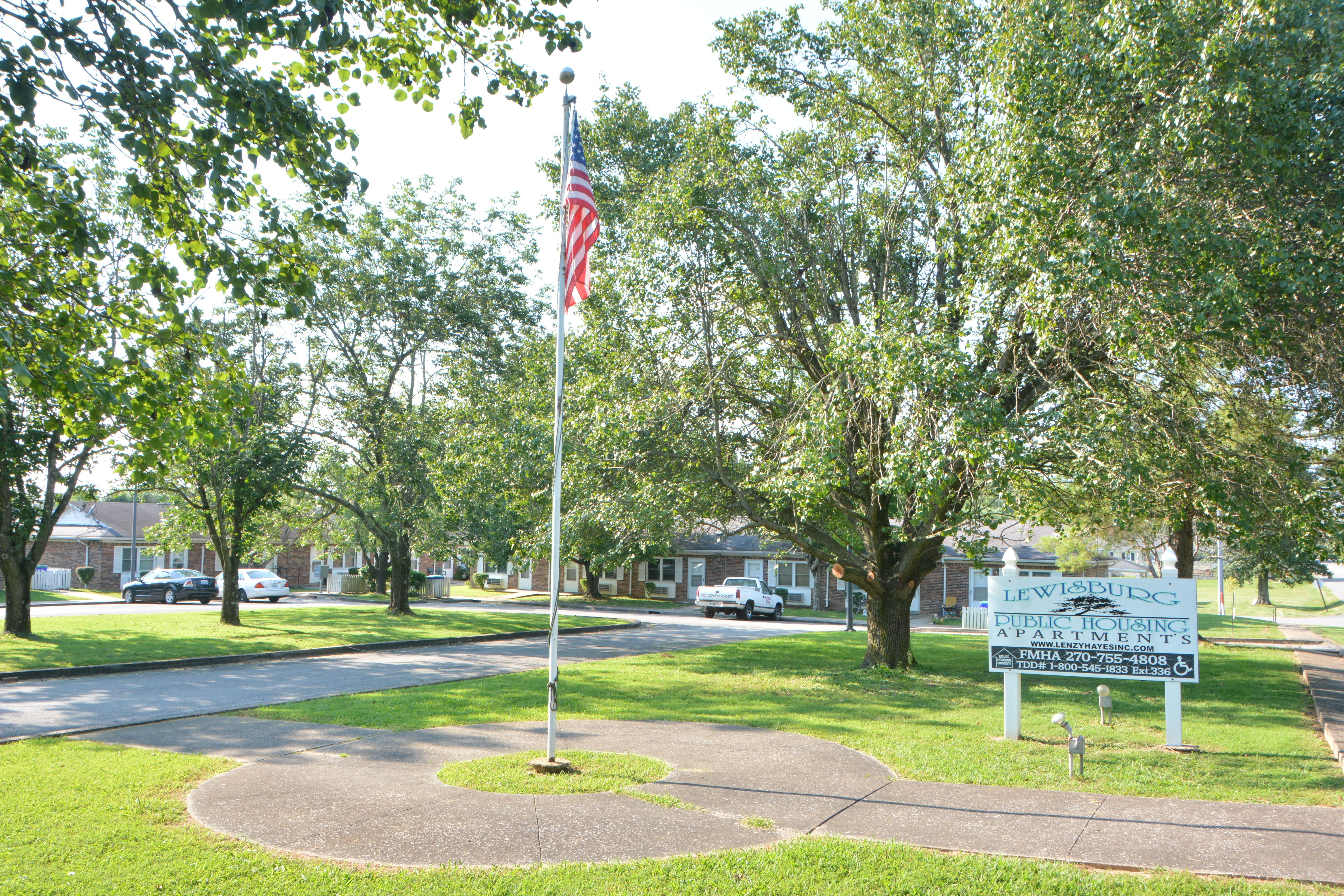 a flag pole with an flag on the corner of a street